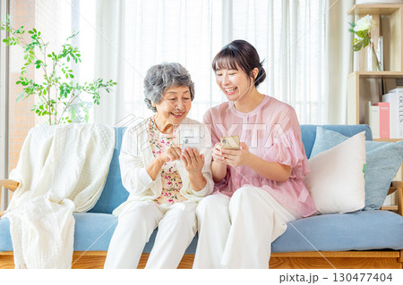 スマホで孫と遊ぶシニア女性 130477404