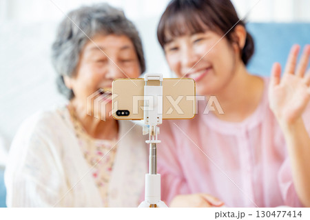 配信をするシニアと孫 130477414