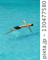 Boy floating relaxed in a swimming pool. 130477580