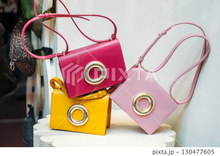 Colorful handbags with oversized metallic rings on display in a boutique window. Dopamine dressing accessories, playful fashion, statement design, mood-boosting style Colorful handbags with oversized metallic rings on display in a boutique window. Dopamine dressing accessories, playful fashion, statement design, mood-boosting style 130477605