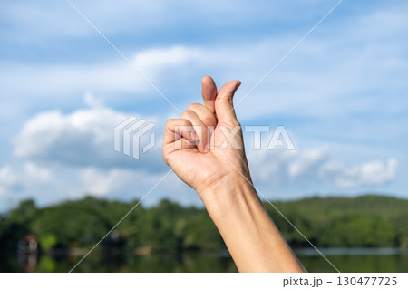 Korean Finger Heart Sign Made by Hand in Outdoor Nature Scene 130477725