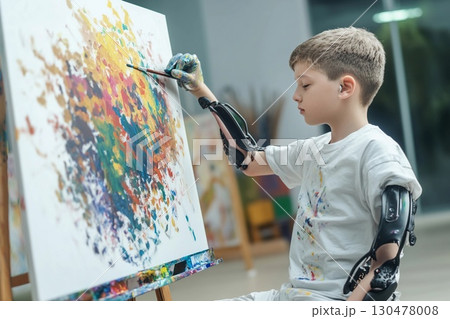 Creative artist with prosthetic arms passionately expresses himself through painting in an art studio space during daytime Creative artist with prosthetic arms passionately expresses himself through painting in an art studio space during daytime 130478008