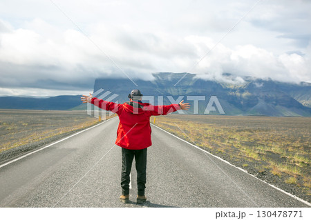Discovering the vast landscapes of Iceland with open arms in a moment of awe Discovering the vast landscapes of Iceland with open arms in a moment of awe 130478771