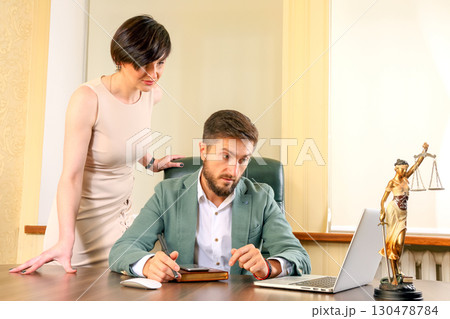 Business meeting between a man and woman in a professional office setting 130478784