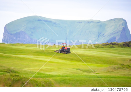 Golf course maintenance in Iceland with stunning green hills in the background 130478796