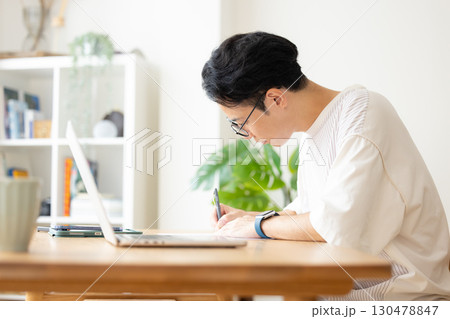 リビングで勉強をしているミドル男性 130478847