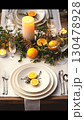 Thanksgiving tablescape , pine cones, and glowing string lights adorning rustic Thanksgiving tablescape with white dinnerware, golden utensils, and sparkling champagne glasses, Thanksgiving 130478928