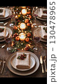 Candlelight glowing near rustic pumpkins, greenery, string lights creating intimate seasonal dining atmosphere with soft autumn warmth 130478965