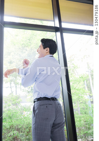 窓際でストレッチする休憩するビジネスマン 130479186