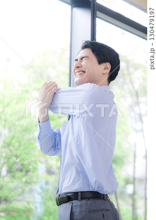 窓際でストレッチする休憩するビジネスマン 130479197