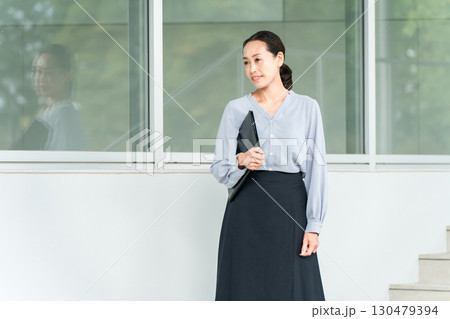学校の廊下を移動する教員・教師の女性 130479394