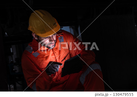 Engineer man technician male working at night shift with tablet technology device on site service 130479555