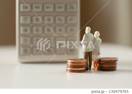 計算機の前に立つミニチュアの老夫婦と硬貨 年金 老後のお金イメージ  計算機の前に立つミニチュアの老夫婦と硬貨 年金 老後のお金イメージ  130479765