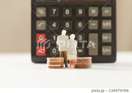 計算機の前に立つミニチュアの老夫婦と硬貨 年金 老後のお金イメージ  130479766
