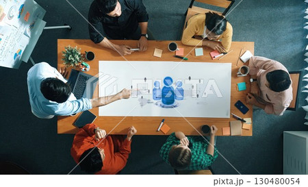Diverse Team Collaborating Over Conference Table with Charts and Tablet in Modern Office Setting for Business Development Strategy. Raster 130480054