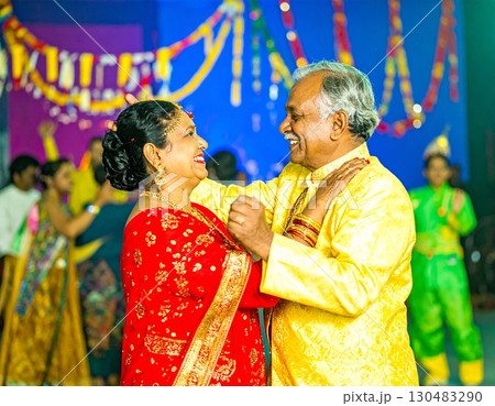 Elderly colorful fashionable couple embraced happily smiling sing in front of music stage 130483290
