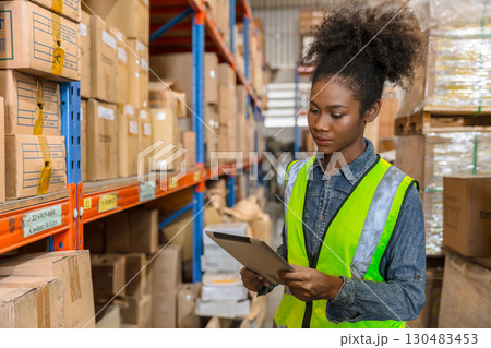 African black young smart worker working in cargo warehouse inventory employee staff with tablet 130483453