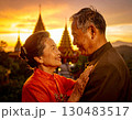 Elderly couple embraced happily smiling in front of temple at sunset 130483517