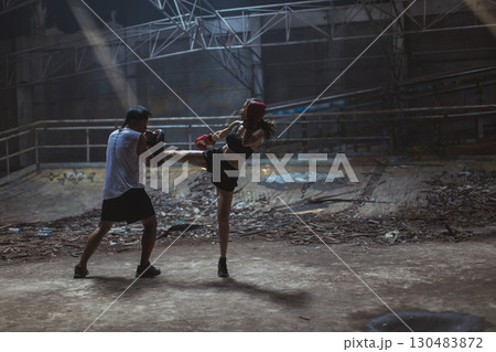 Thai boxing, Women fighter training kick boxing with trainer in ruin building ,Asian martial arts Thai boxing, Women fighter training kick boxing with trainer in ruin building ,Asian martial arts 130483872