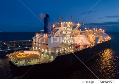 Aerial of Liquified Natural Gas LNG carrier moored to a small gas terminal at dusk. Fuel crisis. Sanctions Aerial of Liquified Natural Gas LNG carrier moored to a small gas terminal at dusk. Fuel crisis. Sanctions 130484511
