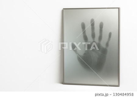A hand behind frosted glass, a palm print. Space for text. 130484958