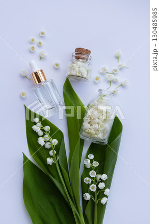 Glass bottle of lily of the valley essential oil with fresh flowers. Copy space. Glass bottle of lily of the valley essential oil with fresh flowers. Copy space. 130485985