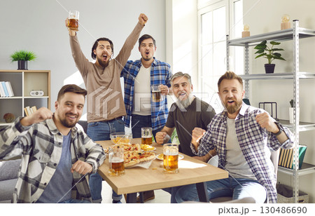 Group of male friends enjoying weekend, having party, watching football, and cheering 130486690