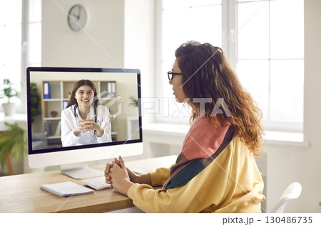 Sick woman listening recommendations having online video call with a doctor at home. 130486735