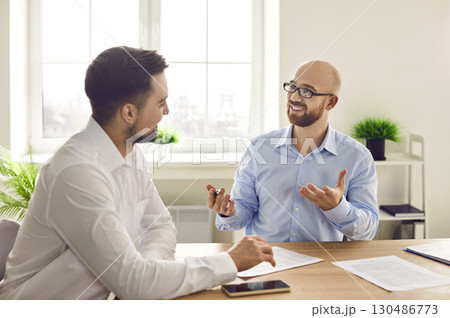 Two business men at work in office. Company employers talking at the desk on workplace. 130486773