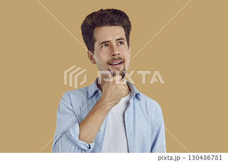 Young handsome smiling man with a doubtful thoughtful expression. Young handsome smiling man with a doubtful thoughtful expression. 130486781