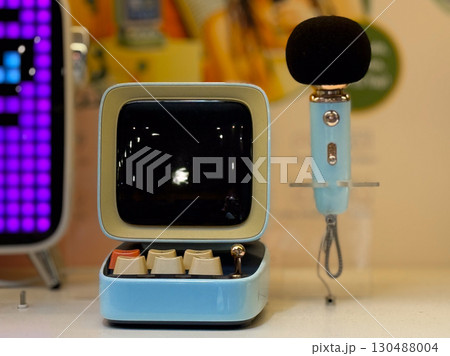 Retro microphone and screen display in modern retail space. Technology, communication, and entertainment in lifestyle and consumer culture. Retro microphone and screen display in modern retail space. Technology, communication, and entertainment in lifestyle and consumer culture. 130488004