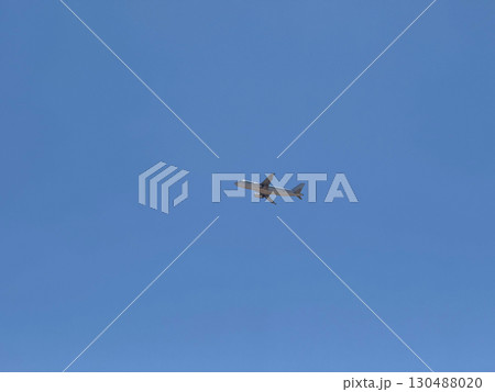 Airplane flying in clear blue sky at high altitude with visible red tailfin. Aviation, transportation, speed, and global connectivity through air travel. Airplane flying in clear blue sky at high altitude with visible red tailfin. Aviation, transportation, speed, and global connectivity through air travel. 130488020