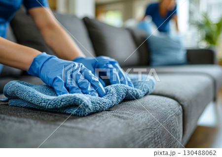 woman hand in blue glove cleaning sofa. woman hand in blue glove cleaning sofa. 130488062