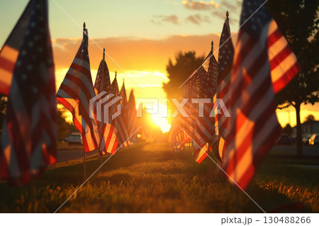 A row of USA flags standing in Remembrance on Memorial Day in the Unit amidst sunlight. 130488266