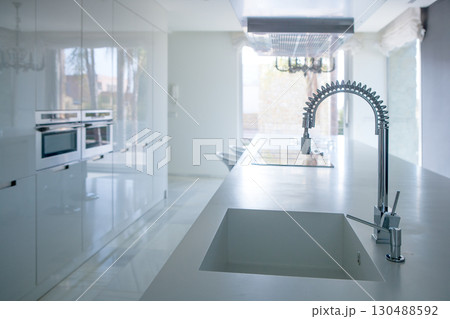 Modern white kitchen perspective with integrated bench Modern white kitchen perspective with integrated bench 130488592
