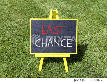Last chance symbol. Concept word Last chance on beautiful black blackboard. Beautiful green grass lawn background. Black blackboard. Business last chance concept. Copy space. Last chance symbol. Concept word Last chance on beautiful black blackboard. Beautiful green grass lawn background. Black blackboard. Business last chance concept. Copy space. 130488775