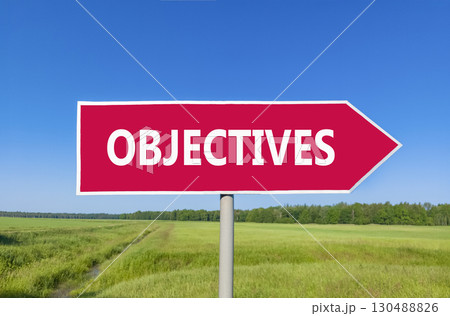 Objectives symbol. Concept word Objectives on beautiful red road sign. Beautiful blue sky green grass and forest peaceful nature background. Business objectives concept. Copy space. 130488826