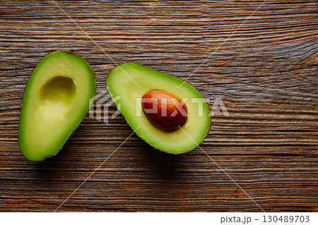 avocado cut on aged wood table board avocado cut on aged wood table board 130489703