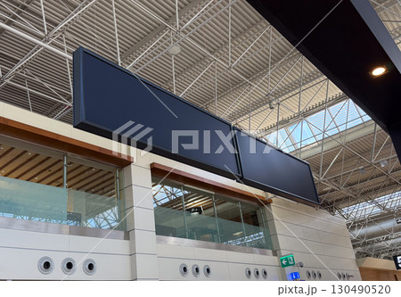 Large empty display boards in an airport terminal interior. Travel, technology, and navigation in modern transport infrastructure. 130490520