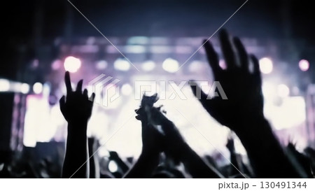Dark silhouetted hands clapping, rising during live concert, signaling musical passion and collective audience energy 130491344