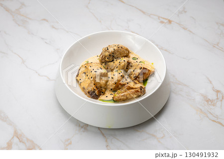 Chicken in creamy mustard sauce with black sesame, served on white marble background 130491932