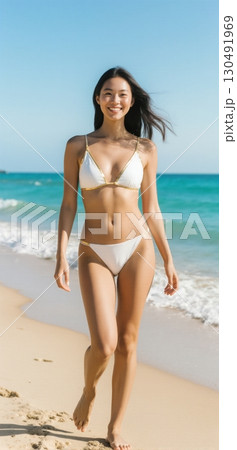 Young woman in white bikini walking on tropical beach enjoying summer vacation 130491969