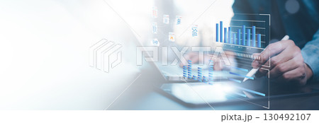 Businessman using computer for development and Analytics Data technology management System for report marketing strategy planning. graph analysis and information on a futuristic virtual screen. 130492107