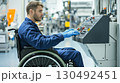 Young factory worker in a wheelchair uses a complex control panel, showcasing accessibility and inclusion in the industrial workplace 130492451