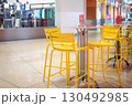 ショッピングモールの中のカフェスペース。黄色の椅子とテーブル 130492985
