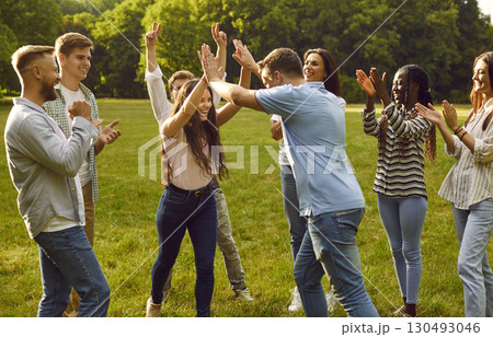 Happy students friends standing together outdoor in summer park and having fun in nature. 130493046
