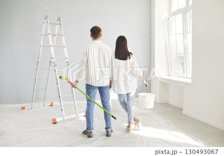Married young couple planning new flat repair, happy husband and wife enjoying interior decoration  130493067