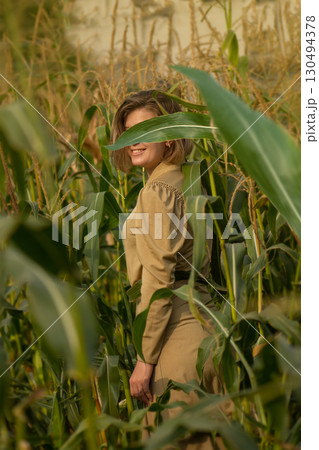 Beautiful model girl posing at camera on morning sunrise over the corn field. Funny joyful woman with cute smile Beautiful model girl posing at camera on morning sunrise over the corn field. Funny joyful woman with cute smile 130494378