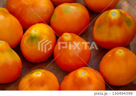 Healthy organic tomato yellow truffle on a wooden background. Tomatoes yellow truffle on wooden background. 130494399