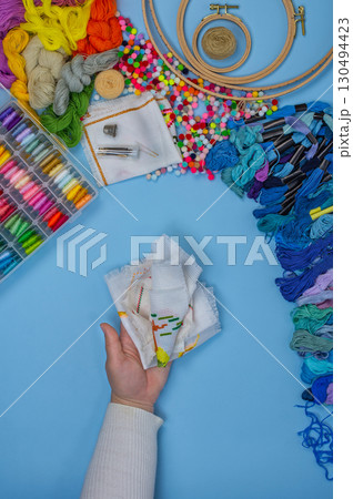 Remote home work. Woman making handmade embroidery. View of the cross stitch process. 130494423